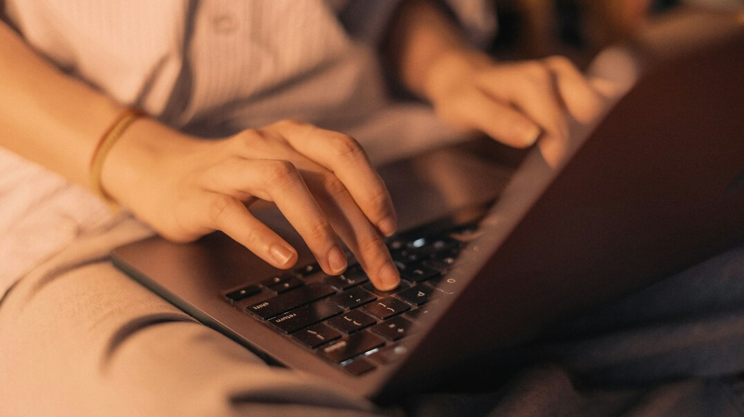 mystery writer typing on laptop