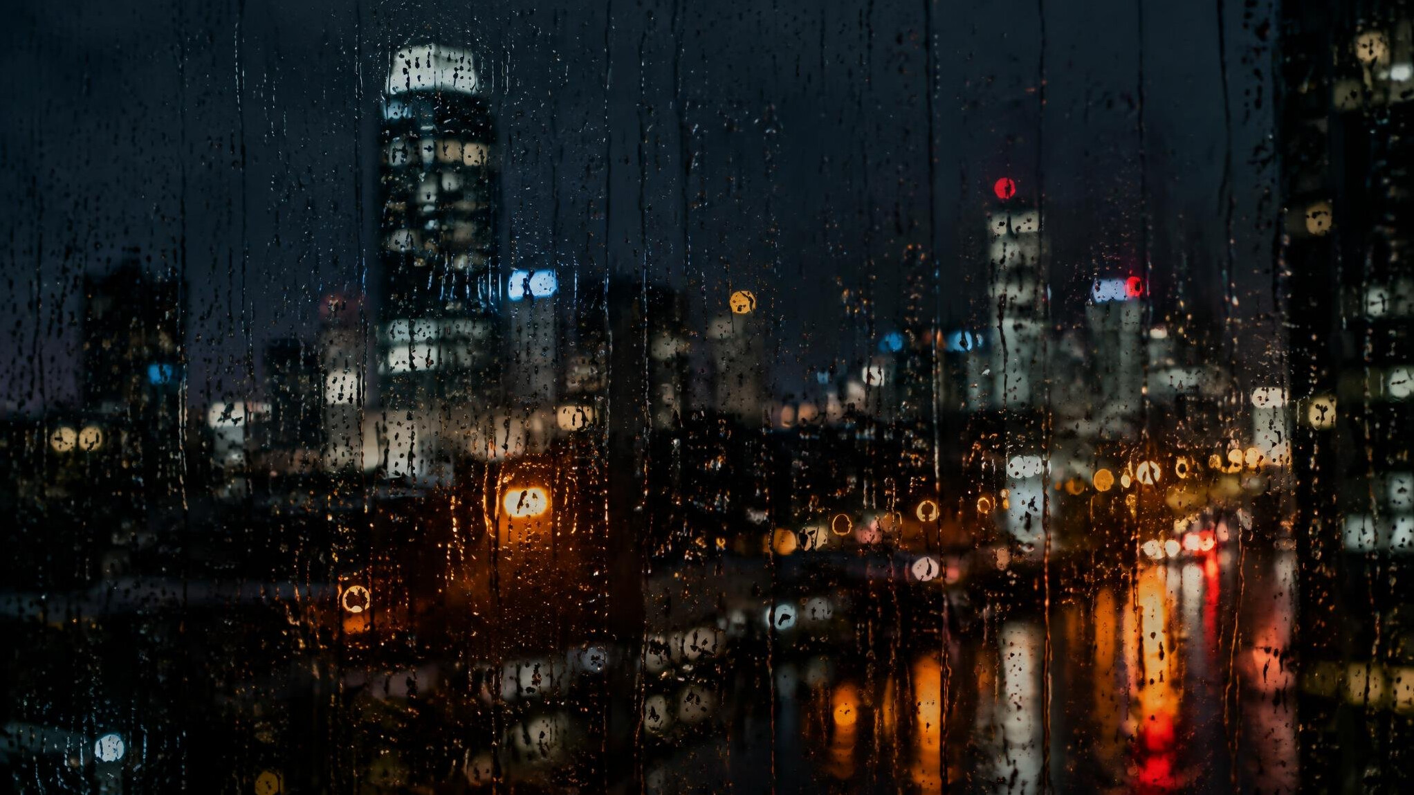 Rain droplets on a dark window at night